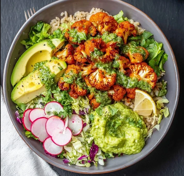 Spicy Buffalo Cauliflower Bowl garnished with fresh herbs and served in a bowl.