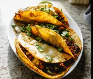 Crispy black bean tacos served with cilantro lime sauce on a plate.