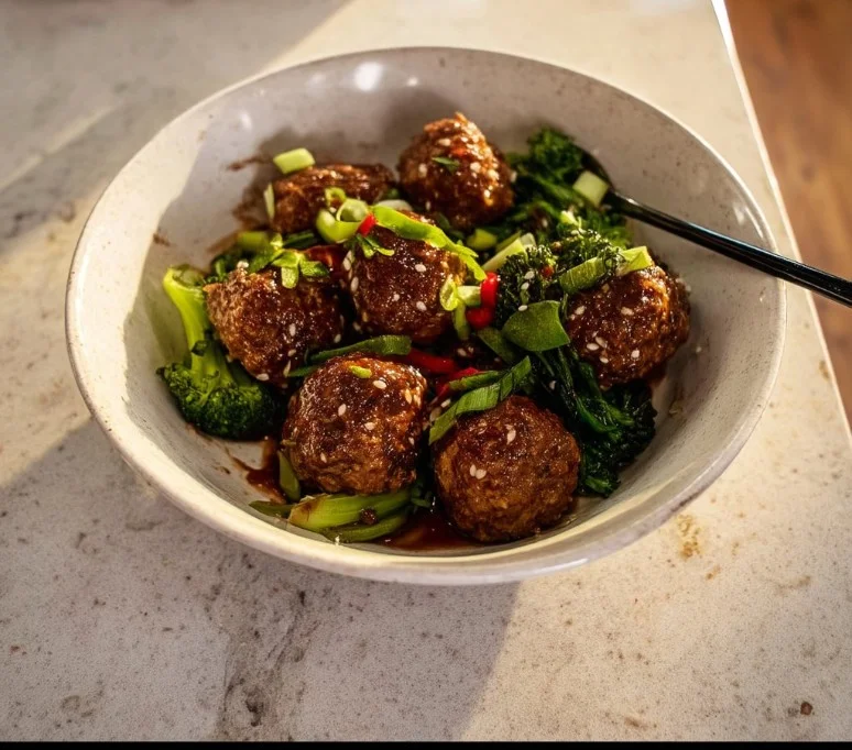 Sticky Mongolian beef meatballs served in a bowl with sauce and green onions